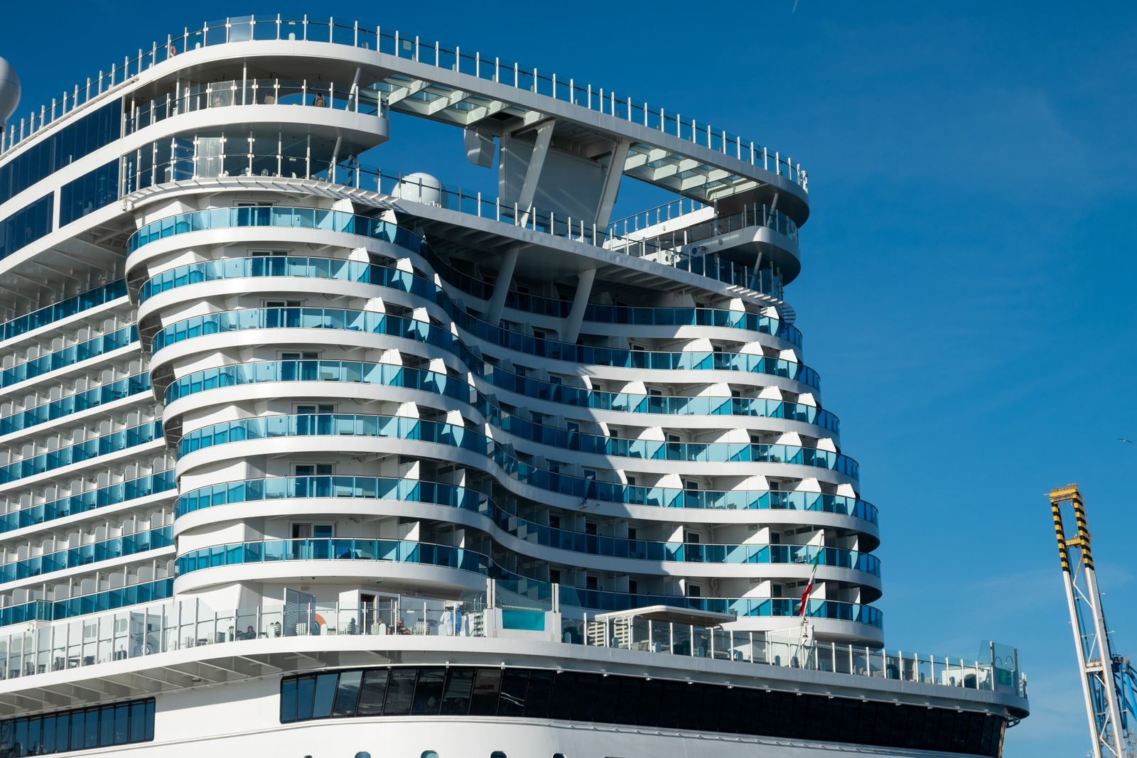 Stern of a large cruise ship with rows of balcony cabins, the cabins guests bid on with a cruise upgrade bid